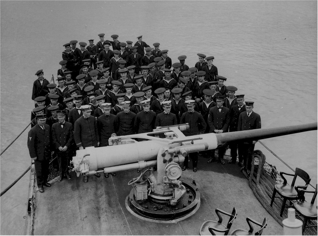 The crew of USS Allen posing behind the 4-in main gun.