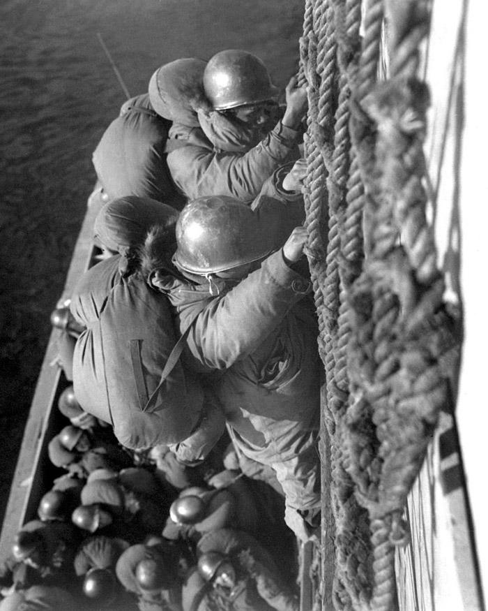 Troops climbing back a rope net onto their boat